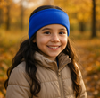 Kind trägt Wollhuhn Elastisches Öko Stirnband aus dunkelbraunem SPORTFLEECE im herbstlichen Park. Handgefertigt in Deutschland, hält es Ohren warm und windgeschützt.