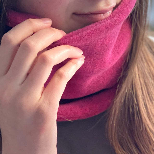 Wollhuhn WINTER Halstuch/Schlupfschal „Unser Wärmster“, doppellagiger Fleece, ideal für Kinder und Erwachsene, zeigt Detailaufnahme eines Gesichts mit handgefertigtem Schal.