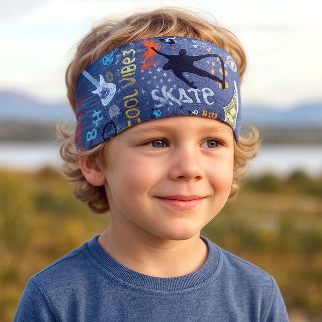 Ein Kind trägt das Wollhuhn Elastisches Öko Stirnband / Haarband Jersey Zweilagig Breit Cool Stuff Jeansblau, handgefertigt aus weicher, hautfreundlicher Bio-Baumwolle.