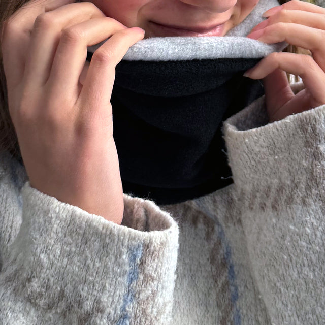 Wollhuhn WINTER Halstuch/Schlupfschal „Unser Wärmster“: Frau trägt handgemachten, doppellagigen Fleece-Loop, ideal für Kinder und Erwachsene, schützt Hals vor Kälte.