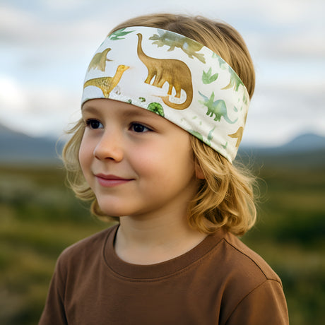 Kind mit Wollhuhn Elastisches Öko Stirnband Jersey Zweilagig Breit Dinos Beige, handgemacht und vielseitig, ideal für Schule und Outdoor-Aktivitäten.