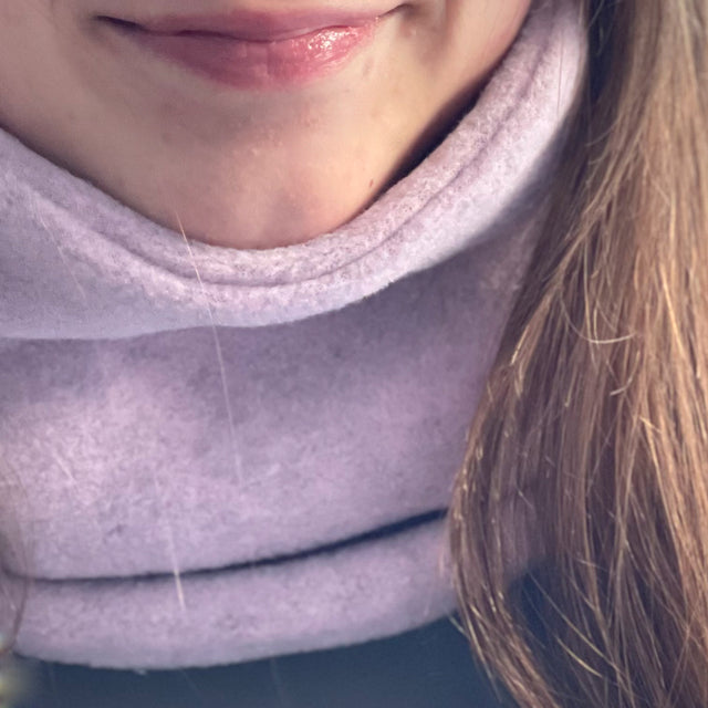Nahaufnahme eines Gesichts mit Wollhuhn WINTER Halstuch/Schlupfschal „Unser Wärmster“, doppellagig, einfarbig Rosé Meliert, ideal für kalte Tage und winddicht.
