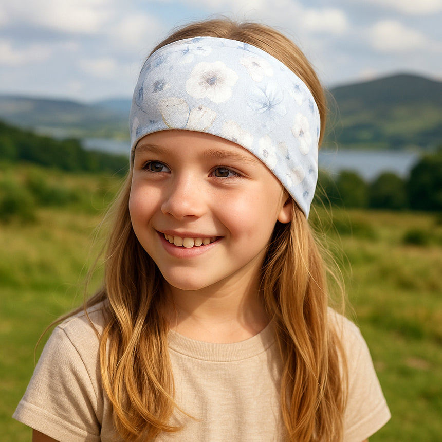 Wollhuhn Elastisches Öko Stirnband/Haarband Jersey Zweilagig Breit Blumen Zartblau – Mädchen trägt handgefertigtes, dehnbares Stirnband für Outdoor-Aktivitäten, ideal unter Helmen.