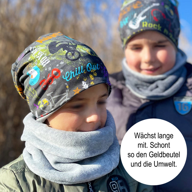 Zwei Kinder tragen Wollhuhn Öko Long Beanie, eine wendbare, zweilagige Mütze aus Baumwolljersey, ideal für ganzjähriges Tragen.