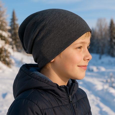 Kind mit Wollhuhn Öko Long Beanie im Schnee; handgemachte, zweilagige Wendemütze, ideal für milde Wintertage. Perfekt für modischen, bequemen Tragekomfort.