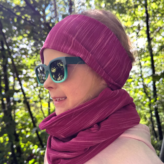 Mädchen trägt Wollhuhn LONG Loop, Jersey- oder Fleecefutter, schützt vor Kälte und Sonne. Handgemacht und komfortabel, ideal für Kinder und Erwachsene.
