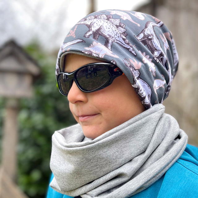 Person mit Sonnenbrille und Wollhuhn Öko Shorties, zweilagige Wendemütze. Handgemacht, ideal für aktive Kinder, bietet Komfort und Wärme bei jedem Wetter.