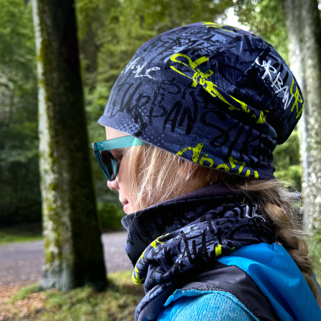 Frau trägt Wollhuhn LONG Loop, handgemacht, über ihrem Schal; ideal für Komfort und Schutz beim Wandern, vielseitig für Kinder und Erwachsene.