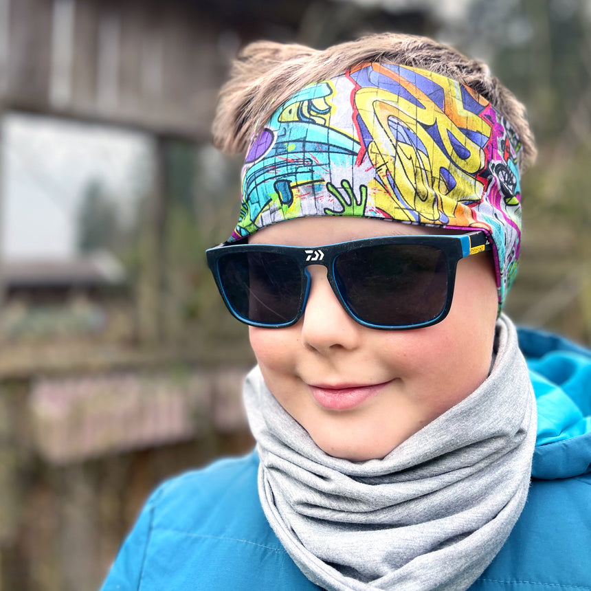 Person trägt Wollhuhn Elastisches Öko Stirnband, handgemacht, zweilagig, vielseitig als Stirn- oder Haarband, ideal für Outdoor-Aktivitäten. Perfekt unter Helmen tragbar.