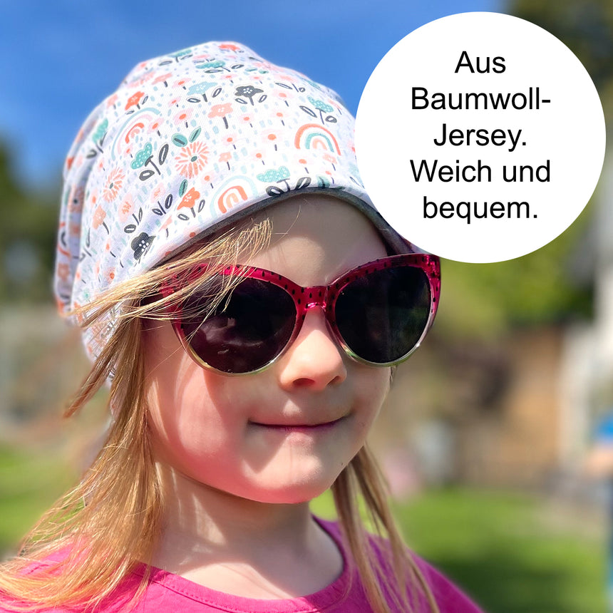 Mädchen trägt Wollhuhn Öko Shorties Wendemütze, zweilagig. Stilvolle Beanie aus weichem Baumwolljersey, ideal für Kinder, sorgt für Komfort und Wärme.