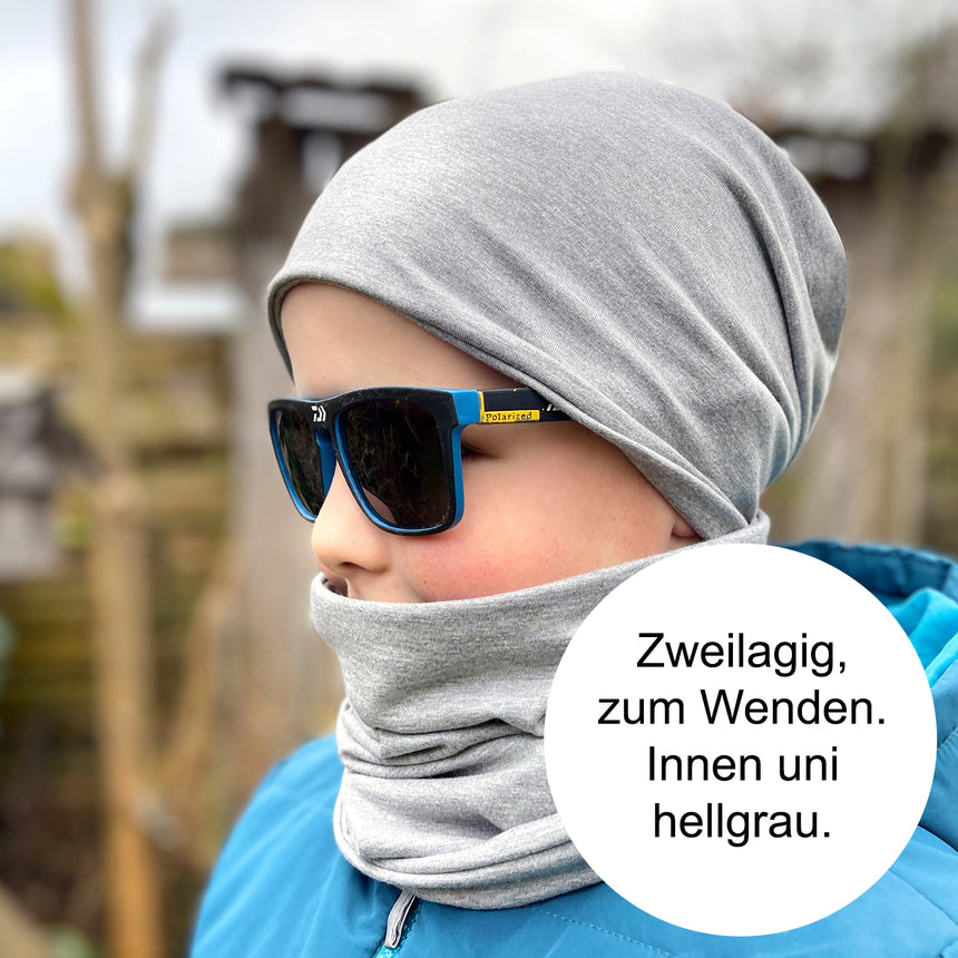 Junge trägt Wollhuhn Öko Shorties Wendemütze, zweilagig und bequem, mit Sonnenbrille und Schal, ideal für ganzjähriges Tragen.