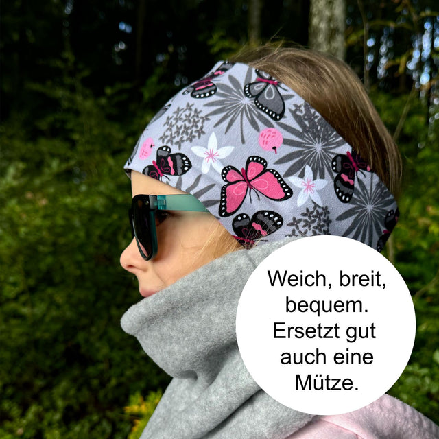 Frau trägt Wollhuhn Elastisches Öko Stirnband aus zweilagigem Fleece, ideal für kaltes Wetter. Hergestellt in Deutschland, schützt Ohren gegen Wind und Wetter.