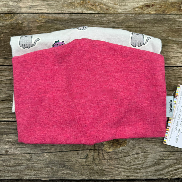Gefalteter pinker Pullover auf Holztisch, repräsentativ für die Beanie Überraschungstüte von Wollhuhn, handgefertigte Mützen aus hochwertigen Materialien, sorgsam in Deutschland produziert.