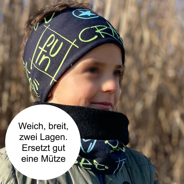 Ein Kind trägt das Wollhuhn Elastisches Öko Stirnband / Haarband Jersey Zweilagig Breit Splatter Oliv/Orange, ideal für Outdoor-Aktivitäten und handgefertigt aus Bio-Baumwolle.