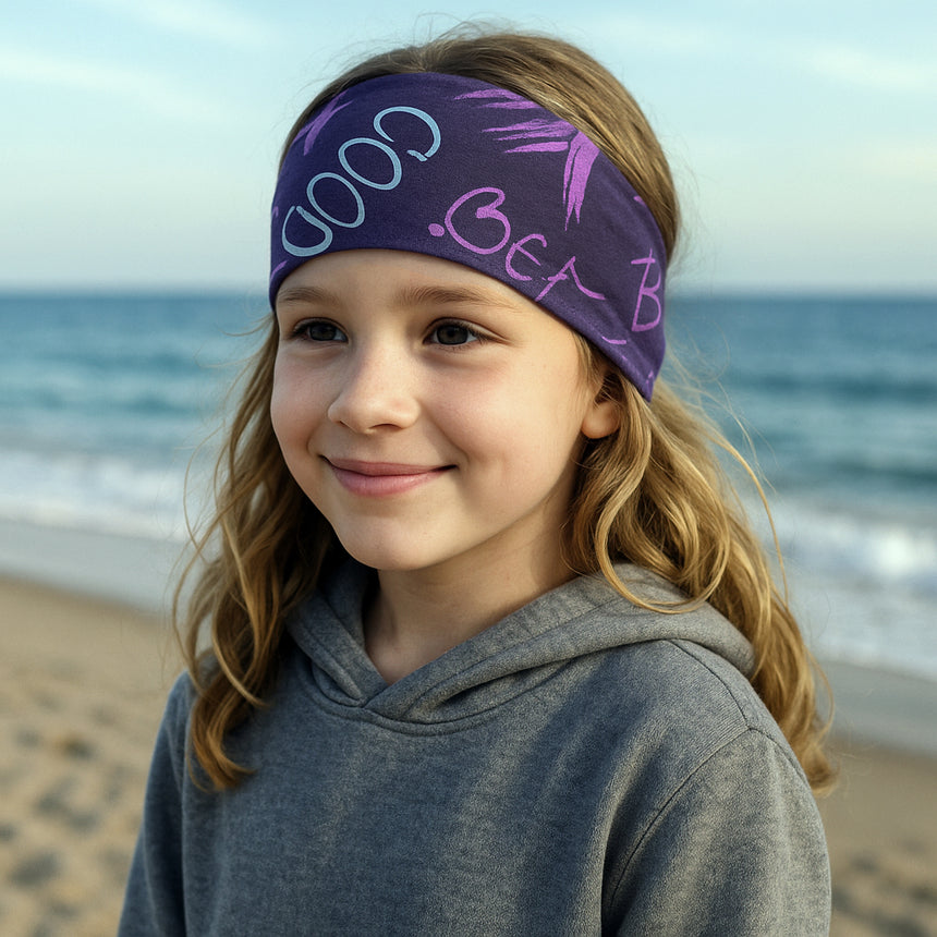 Mädchen am Strand trägt Wollhuhn Elastisches Öko Stirnband, handgefertigt, zweilagig, vielseitig tragbar für Aktivitäten. Perfekt für Kinder und Erwachsene.
