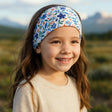 Ein Mädchen trägt das Wollhuhn Elastisches Öko Stirnband, handgemacht aus Jersey, ideal für Freizeit- und Outdoor-Aktivitäten. Perfekt für Kinder und Erwachsene.