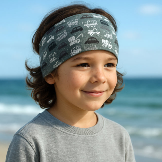 Junge am Strand trägt Wollhuhn Elastisches Öko Stirnband, handgemacht, weich und vielseitig. Perfekt für Freizeit und sportliche Aktivitäten. Ideal für Kinder und Erwachsene.