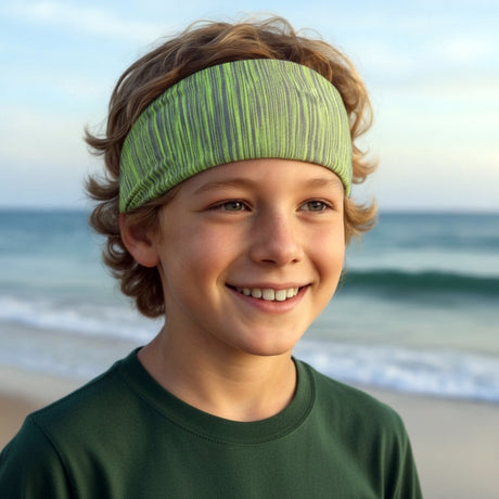 Junger Junge am Strand trägt Wollhuhn Elastisches Öko Stirnband / Haarband Jersey Zweilagig Breit Lines Grüntöne, ideal für Schule, Freizeit und Sport.