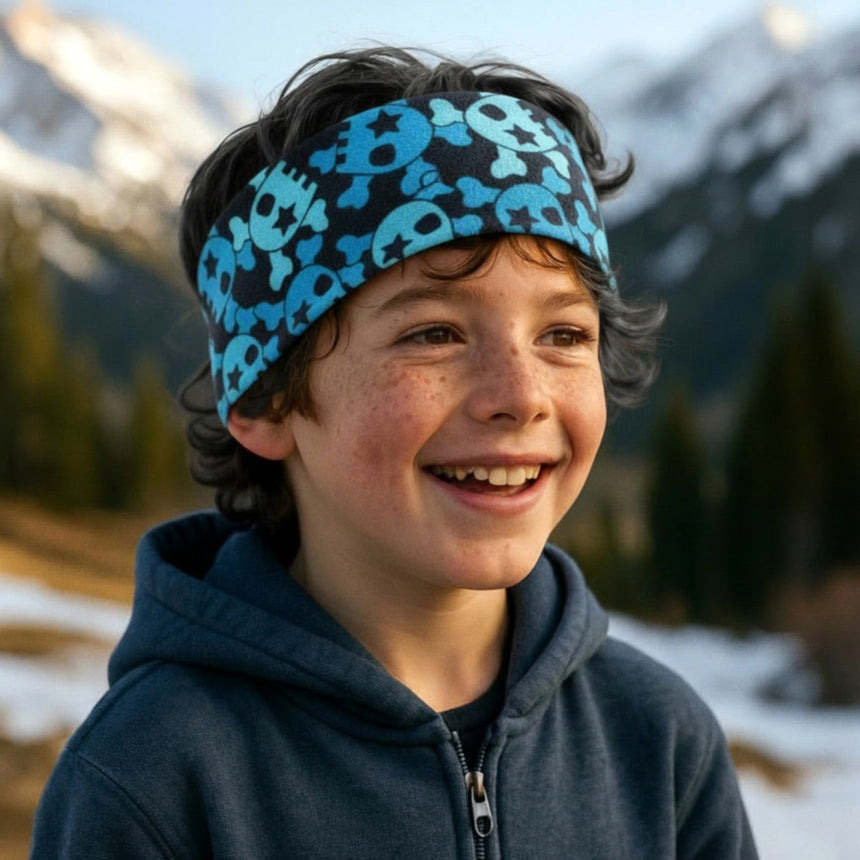 Junger Junge im Freien trägt das Wollhuhn Elastisches Öko Stirnband / Haarband Jersey Zweilagig Breit Coole Skulls Blau/Schwarz, perfekt für Outdoor-Aktivitäten.