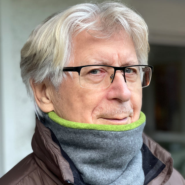 Mann mit Brille und Schal trägt Wollhuhn WINTER Halstuch „Unser Wärmster“, doppellagiger Fleece-Schlupfschal, handgefertigt, ideal für kalte Tage.
