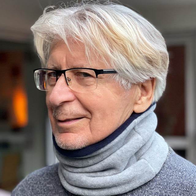 Mann mit Brille trägt Wollhuhn WINTER Halstuch/Schlupfschal „Unser Wärmster“, doppellagiger Fleece, ideal für kalte Tage, handgefertigt in Deutschland.