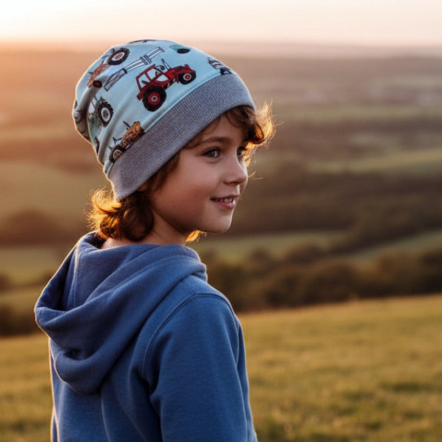 Kind im Freien mit Wollhuhn Dünne Öko Beanie-Mütze Sommer/Übergang Einlagig Maxi Trecker/Traktor Hellblau, zeigt handgemachte, dehnbare Qualität der Mütze.