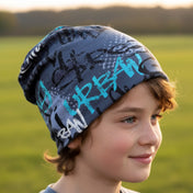 Kind mit Wollhuhn Öko Long Beanie in Blau, trägt slouchy Stil im Freien. Handgemacht aus weichem Öko-Jersey, ideal für ganzjährigen Gebrauch.
