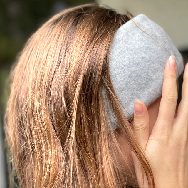 Frau mit grauem Wollhuhn Elastisches Öko Stirnband Fleece Zweilagig Breit Einfarbig Beere Melange, handgefertigt, kuschelig und dehnbar, ideal für kalte Tage.