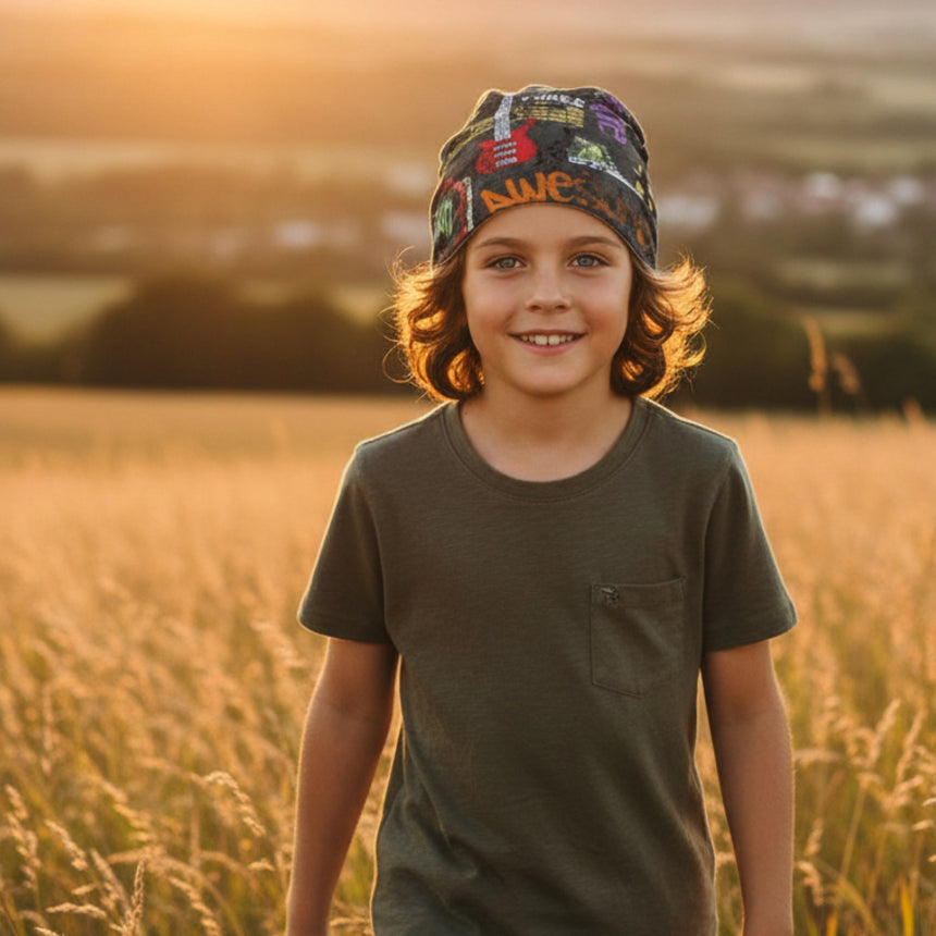 Kind im Sonnenlicht mit Wollhuhn Öko Long Beanie, Wendemütze. Beanie bunt, lässiger slouchy Look, ideal für Übergangszeiten und milden Winter.