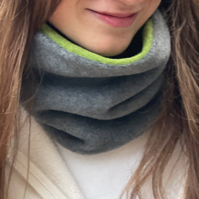 Wollhuhn WINTER Halstuch/Schlupfschal „Unser Wärmster“ aus zwei Lagen Fleece. Eine Frau trägt den gemütlichen und winddichten Schlauchschal. Ideal für kalte Tage.
