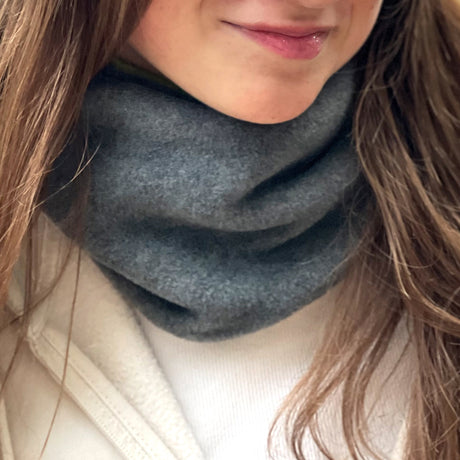 Frau trägt Wollhuhn WINTER Halstuch/Schlupfschal „Unser Wärmster“, doppellagiger Fleece in Anthrazit/Pink, handgefertigt für Wärme und Komfort.