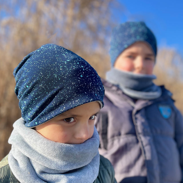 Kinder tragen Wollhuhn Öko Long Beanie / Wendemütze, zweilagig und bequem, ideal für alle Jahreszeiten. Hergestellt aus weichem, nachhaltigem Jersey, wächst mit und hält warm.