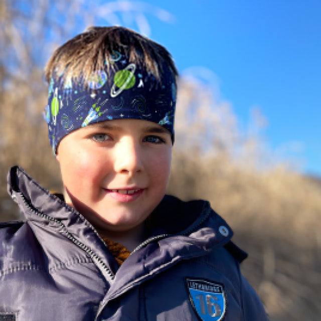 Junge trägt Wollhuhn elastisches Öko Stirnband aus Jersey, zweilagig und breit, ideal für Outdoor-Aktivitäten. Perfekt für Kinder und Erwachsene.